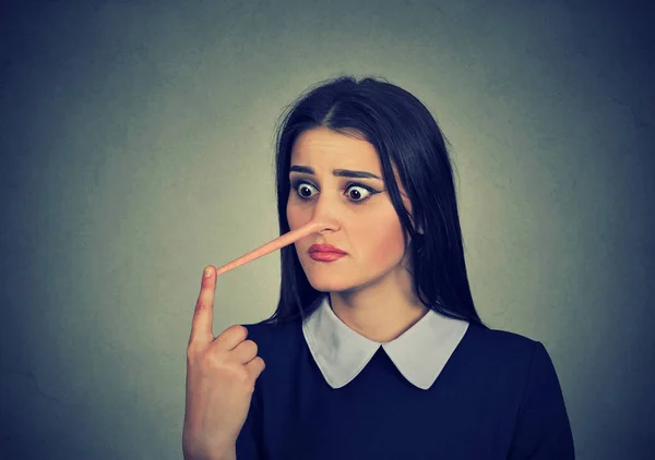 Worried woman with long nose. Liar concept. — Stock Photo, Image