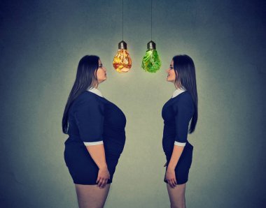 young fat woman looking at happy slim fit girl. Diet choice concept clipart