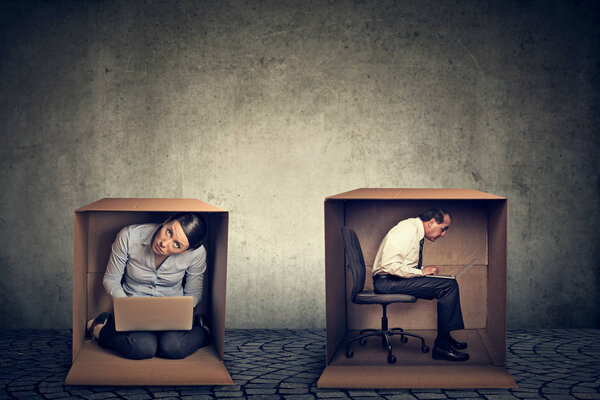 Интроверты. Мужчина и женщина сидят внутри ящиков, работая на ноутбуке
