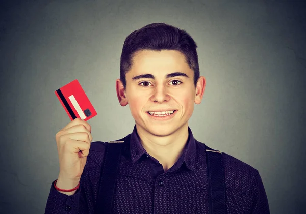 Happy young man showing credit card — Stock Photo, Image
