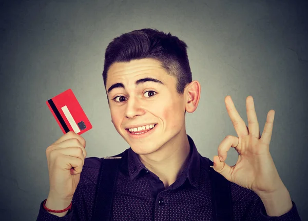 mutlu genç adam Ok işaret gösteren kredi kartıyla 