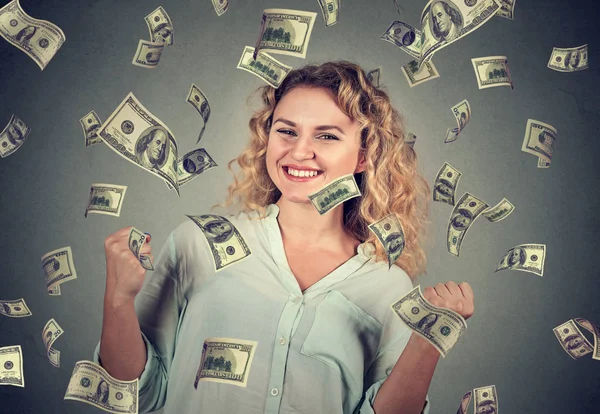 Mujer se regocija bombeo puños celebra el éxito bajo la lluvia de dinero — Foto de Stock