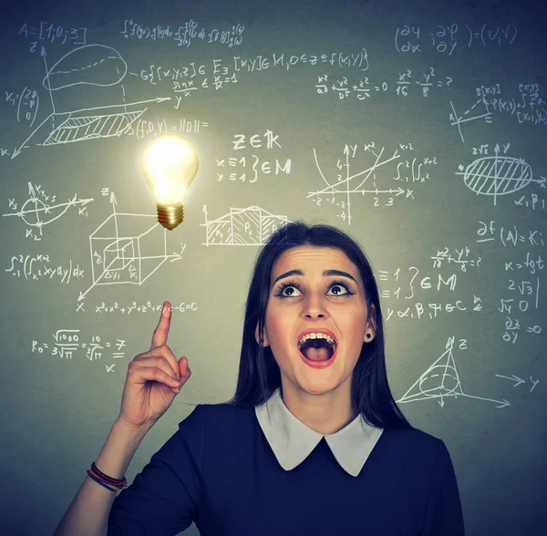 Slimme student met idee gloeilamp wis- en natuurkunde formules op achtergrond — Stockfoto