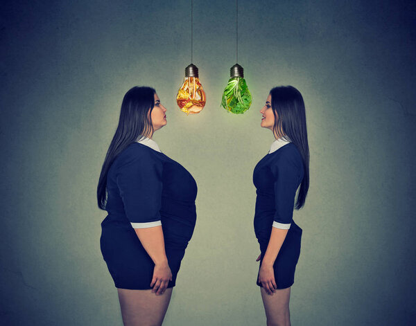 young fat woman looking at happy slim fit girl. Diet choice concept