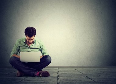 mükemmel teknoloji. Dizüstü bilgisayarda çalışarak katta oturan adam 