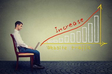 Genç adam bir dizüstü bilgisayar kullanarak Web sitesi trafiğini artırmak için bir planı vardır