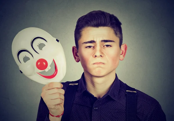 Trieste man gelukkig clown masker opstijgen. Gespleten persoonlijkheid — Stockfoto