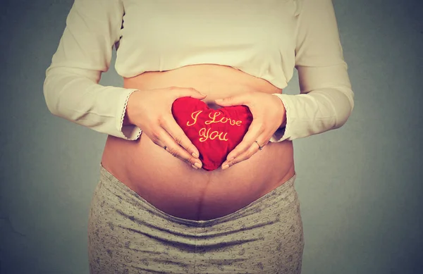 Donna incinta che tiene il cuore con ti amo scrivere — Foto Stock