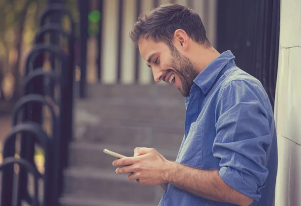 Человек пишет смс на мобильном телефоне на улице — стоковое фото