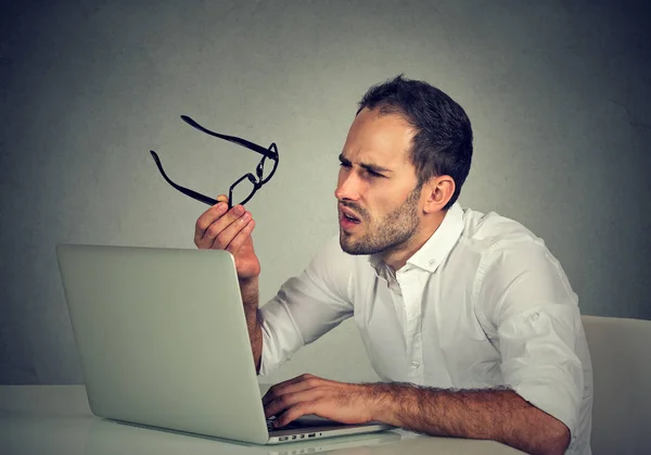 Man with glasses having eyesight problems confused with laptop — Stock Photo, Image