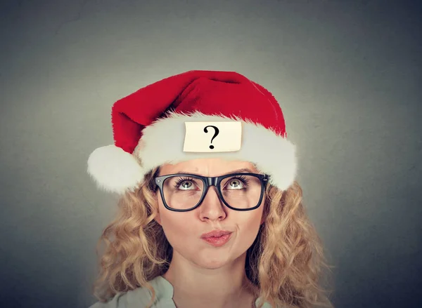 Thinking young woman in santa claus hat with question mark — Stock Photo, Image