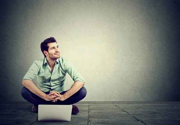 Jonge man met laptop zittend op de vloer — Stockfoto