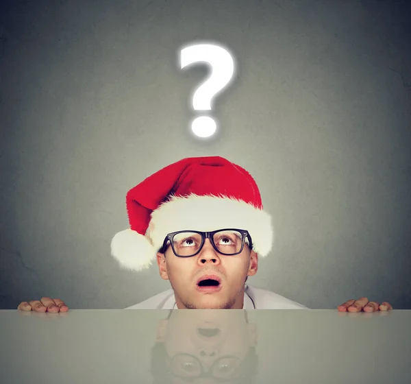 Man in santa hat with question mark wondering about gift — Stock Photo, Image
