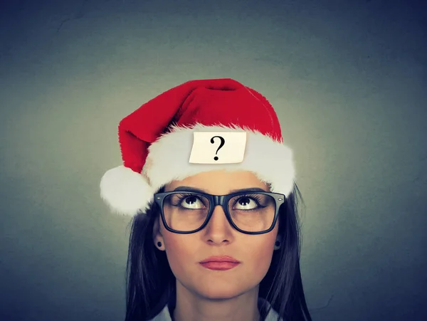 Young woman in santa claus hat with question mark — Stock Photo, Image