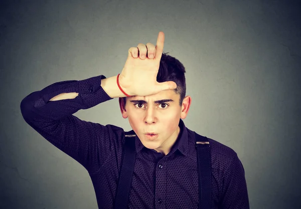 Boze man tonen verliezer teken op zoek met walging op camera — Stockfoto