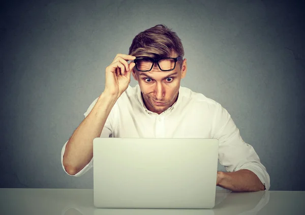 Confused shocked man looking at his laptop — Stock Photo, Image