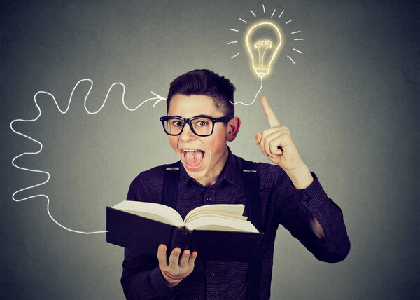 Удивительный человек в очках, читающий книгу приходит с идеей
