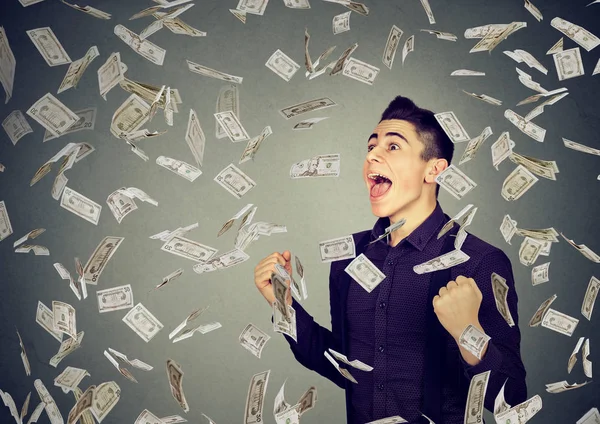 Homem celebra sucesso sob chuva monetária caindo notas de dólar — Fotografia de Stock