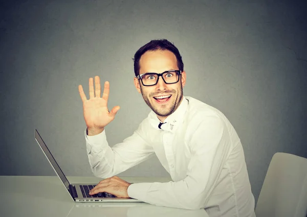 Mann mit Laptop winkt mit der Hand in die Kamera — Stockfoto