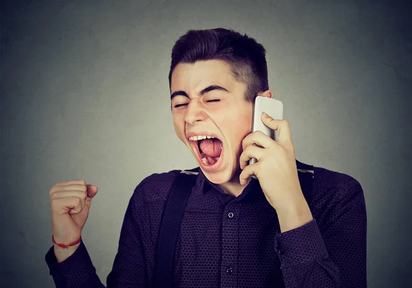 Rozzlobený mladý muž křičí na mobilní telefon — Stock fotografie