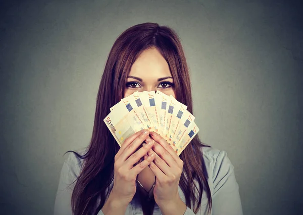 Mujer ocultando su cara detrás de euro dinero ventilador — Foto de Stock