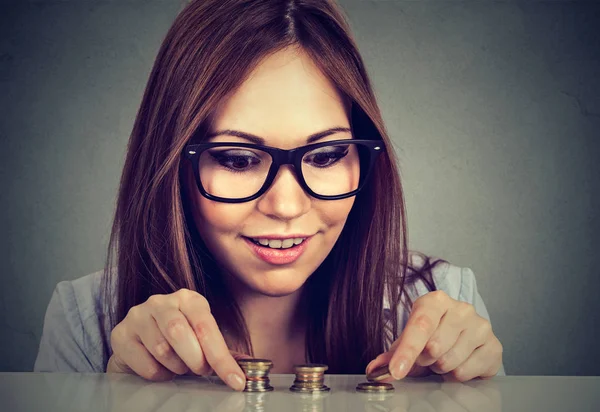 Mujer joven contando dinero apilando monedas — Foto de Stock