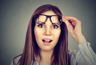 Surprised girl taking off her glasses  clipart
