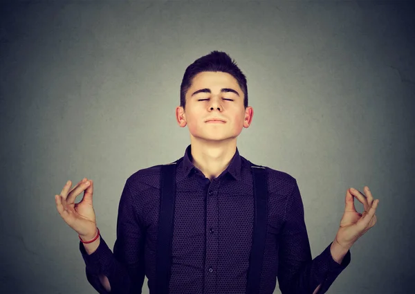 Молодой человек медитирует с закрытыми глазами — стоковое фото
