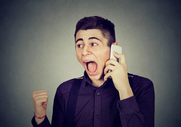 Rozzlobený mladý muž křičí na mobilní telefon — Stock fotografie