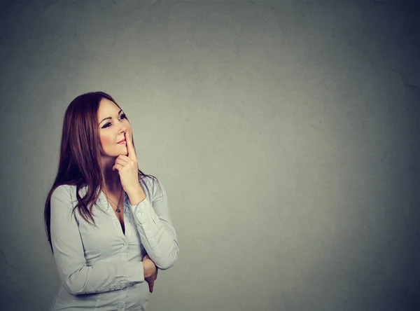 Gelukkige vrouw denken met hand op kin opzoeken — Stockfoto