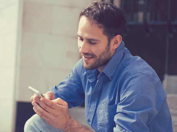 Ευτυχισμένος άνθρωπος γραπτών μηνυμάτων τηλεφώνου που κάθονται στα σκαλοπάτια εκτός γραφείου — Φωτογραφία Αρχείου