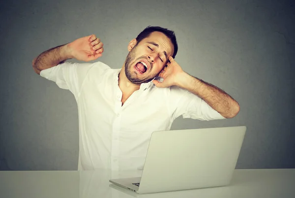 Sleepy werknemer met laptop computer geeuwen — Stockfoto