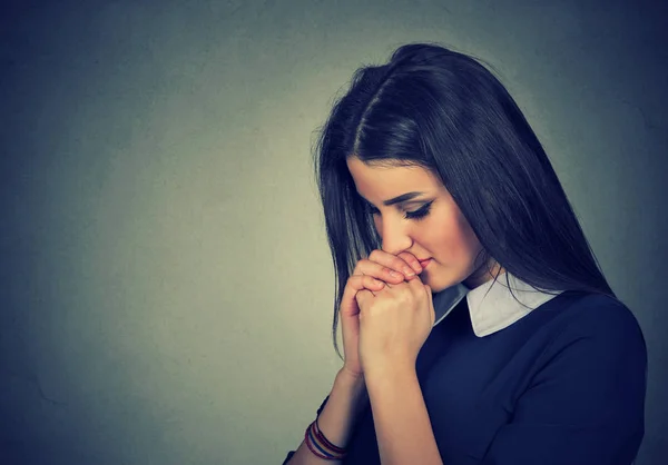Retrato de la triste joven rezando con los ojos cerrados — Foto de Stock