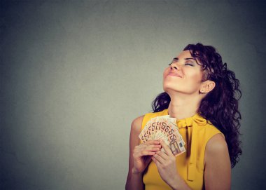 Mutlu genç kadın elinde para tutuyor. 