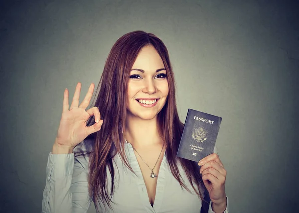 Atractiva joven feliz mujer con pasaporte de EE.UU. dando señal de ok — Foto de Stock