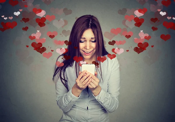 Young woman receiving love sms text message on mobile phone — Stock Photo, Image