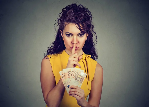 Mujer corrupta y reservada con dinero en euros mostrando un signo shhh — Foto de Stock