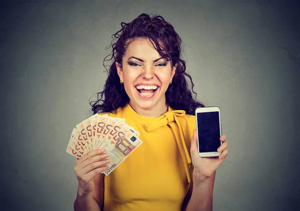 Mujer feliz sosteniendo billetes en euros de teléfono móvil en efectivo —  Fotos de Stock