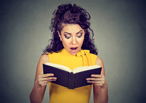 Mulher chocada incrível lendo um livro — Fotografia de Stock