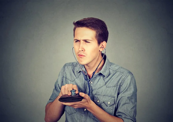 Hombre revisando billetera con estetoscopio. Concepto de éxito financiero — Foto de Stock