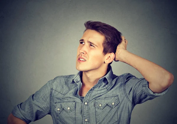 Un uomo che grattava la testa, pensando che non ricorda di aver alzato lo sguardo — Foto Stock