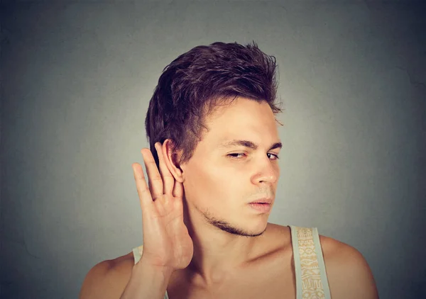Uomo mettendo mano sull'orecchio ascoltando attentamente pettegolezzi — Foto Stock