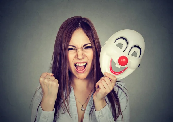 Irritado gritando mulher decolando máscara de palhaço expressando felicidade — Fotografia de Stock