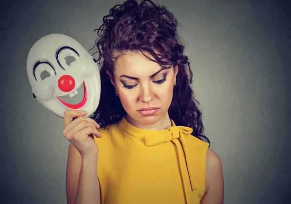 Sorgliga kvinna lyfter clownen masken uttrycker glädje — Stockfoto