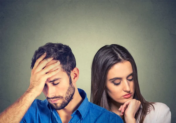 Estressado triste jovem casal homem e mulher olhando para baixo — Fotografia de Stock