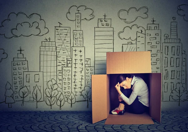 Жінка ховається в коробці на міському фоні хмарочоса — стокове фото