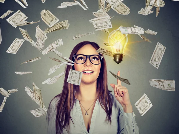 Mujer feliz en gafas tiene una idea exitosa bajo la lluvia de dinero — Foto de Stock