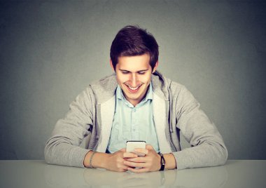 Mutlu adam cep telefonuyla masada oturan 