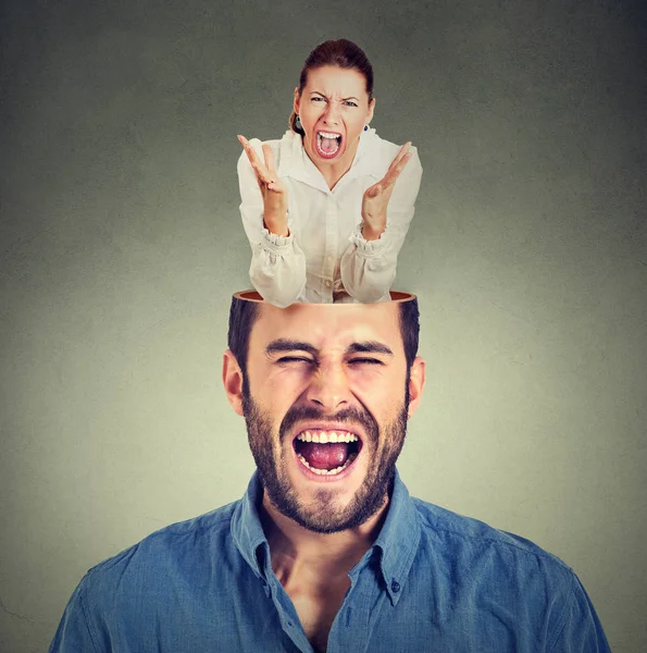 Young angry woman screaming inside head of a frustrated guy — Stock Photo, Image