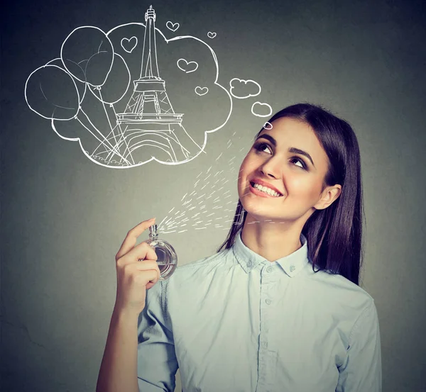 Beautiful woman holding bottle of perfume and smelling aroma — Stock Photo, Image